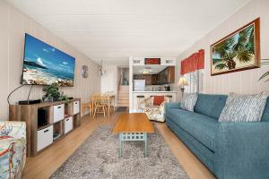 a living room with a blue couch and a table at El Capitan 206 - Dolphin Watch in Ocean City