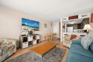 a living room with a blue couch and a table at El Capitan 206 - Dolphin Watch in Ocean City
