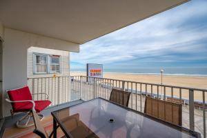 a balcony with a red chair and a beach at El Capitan 206 - Dolphin Watch in Ocean City +44 photos