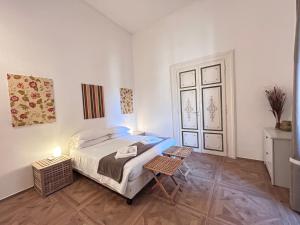 a white bedroom with a bed and a table at Vicolo Doria Apartment in Rome