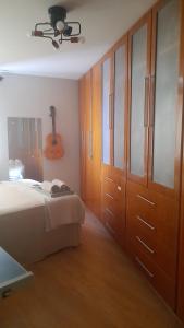 a bedroom with a bed and a guitar on the wall at Apartamento Inteiro em Setor Nobre in Goiânia +42 photos