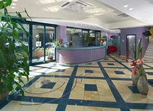a lobby with a reception desk and plants at Sweet Home Appartamenti in Bellaria-Igea Marina