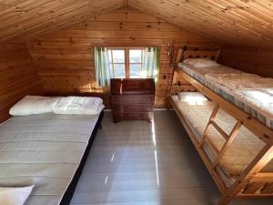 ein Schlafzimmer mit zwei Etagenbetten in einer Blockhütte in der Unterkunft Kloster Gård - Cabins & apartments near Astrid Lindgrens World in Hultsfred