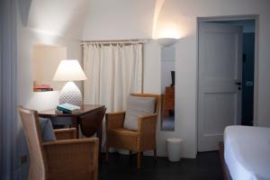 a room with a desk and chairs and a bed at Pantelleria Dream Resort in Pantelleria