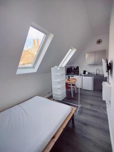 a white room with a bed and a window at Passage des arts - Vieux Lille - 2 personnes in Lille +1 photo