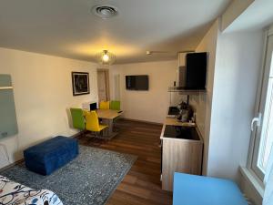 a small room with a kitchen and a table with yellow chairs at Apartment LA DIMORA DEI PESCATORI in Muggia