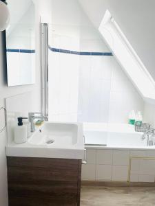 a white bathroom with a sink and a window at Passage des arts - Vieux Lille - 2 personnes in Lille