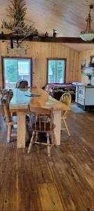 a wooden table and chairs in a room at Le Chaleureux, Picanoc River in Kazabazua