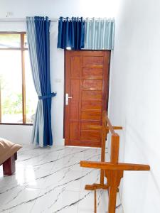 a room with a wooden door and blue curtains at Nerly's Panorama in Bukit Lawang +2 photos