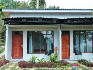 a house with two chairs in front of it at Nerly's Panorama in Bukit Lawang