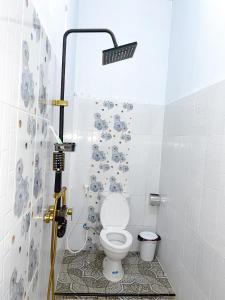 a bathroom with a toilet with a shower in it at Nerly's Panorama in Bukit Lawang