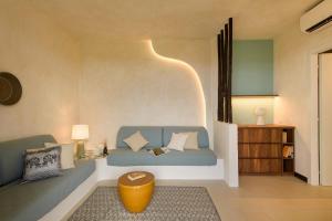 a living room with a blue couch and a table at Hotel Baia Tartuga in Stintino