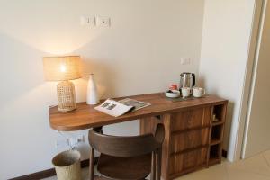 a wooden desk with a lamp and a chair at Hotel Baia Tartuga in Stintino