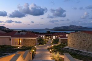 a view of a row of houses at night at Hotel Baia Tartuga in Stintino