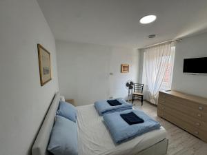 a bedroom with a bed with blue pillows on it at Apartment LA DIMORA DEI PESCATORI in Muggia