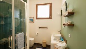 a bathroom with a glass shower and a toilet at Hotel Baia Tartuga in Stintino +60 photos