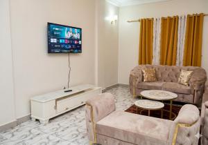 a living room with two couches and a flat screen tv at 2 chambres residence Dovv quartier Odja in Yaoundé