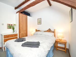 a bedroom with a white bed with a wooden headboard at 3 Bed in Stocksfield oc-32252 in Stocksfield