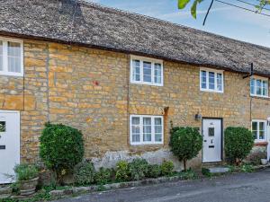 an old stone house with white doors and windows at 2 Bed in Bridport oc-77557 in Loders