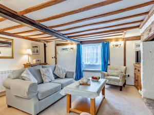 a living room with a couch and a table at 2 Bed in Bridport oc-77557 in Loders