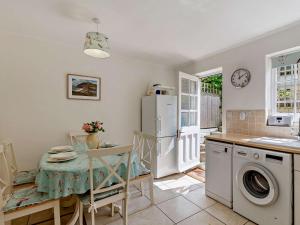 a kitchen with a table and a refrigerator at 2 Bed in Bridport oc-77557 in Loders