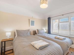 a bedroom with two beds and a window at 3 Bed in Swanage oc-84019 in Swanage