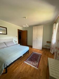 a bedroom with a large bed and a wooden floor at Appartamento Bonomelli in Enguiso