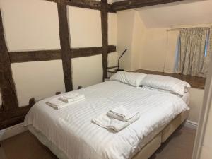 a bedroom with a bed with two towels on it at The Kings Arms in Cleobury Mortimer