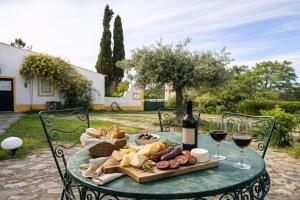 a table with a plate of food and glasses of wine at Monte Machial Private Villa, Pool & Event Space in Alvega