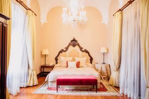 a bedroom with a large bed and a chandelier at Convento do Espinheiro, Historic Hotel & Spa in Évora +48 photos
