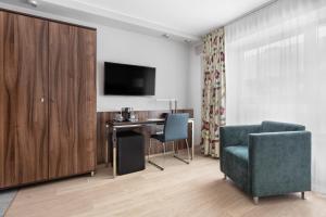 a room with a desk and a chair and a tv at Hotel Moderno Poznań in Poznań