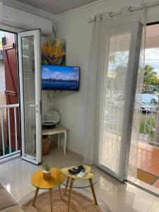 a living room with a tv on the wall at Soleil éclatant in Sainte-Anne