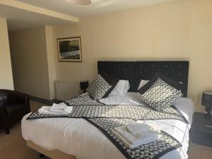 a bedroom with a large bed with black and white pillows at The Kings Arms in Cleobury Mortimer