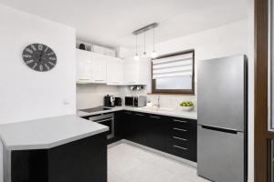 a kitchen with a refrigerator and a clock on the wall at Marica Apartment in Plovdiv +6 photos