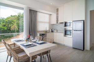 a kitchen with a table with chairs and a refrigerator at The Residence Seaview in Nathon Bay