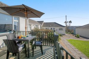 a table and chairs with an umbrella on a deck at 2 Bed in Mullion oc-k7968 in Mullion