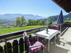 a table with two chairs and an umbrella on a balcony at Ferienhof Kühberg mit schönstem Panoramablick in Blaichach