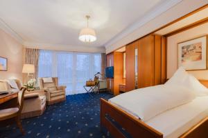 a hotel room with a bed and a desk at Hotel & Spa Fontenay in Bad Wörishofen +31 photos