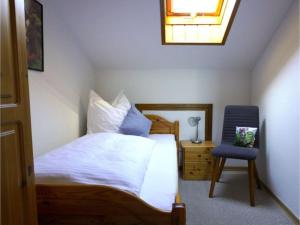 a bedroom with a bed and a chair and a window at Ferienhof Kühberg mit schönstem Panoramablick in Blaichach