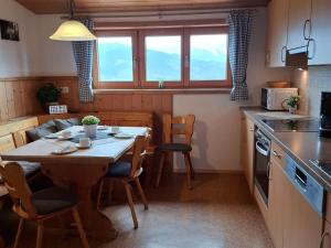 a kitchen with a table and chairs and a table and a table and a kitchen at Ferienhof Kühberg mit schönstem Panoramablick in Blaichach