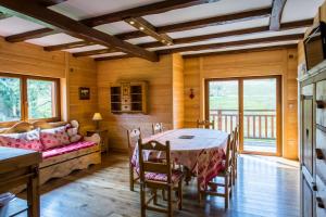 a dining room with a table and a couch at Hotel Restaurant Mont Champ du Feu in Belmont