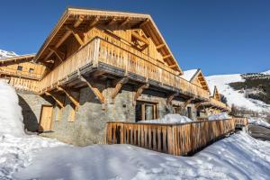 a log cabin in the snow with snow at Chalets Choseaux Lézami in Saint-Sorlin-dʼArves