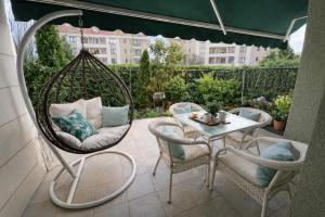 a porch with a swing and a table and chairs at Marica Apartment in Plovdiv