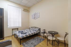 a bedroom with a bed and a table and chairs at Hostel in the center in Kyiv +34 photos