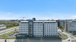 a large white building in a city with cars at Hotel Cabin in Reykjavík