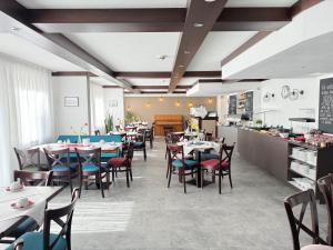 a restaurant with tables and chairs and a kitchen at Burghotel Nürnberg in Nuremberg