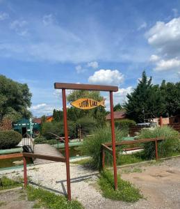 a sign for a park with two benches at Chaty oddych pri vode, aj pre rybárov in Veľké Úľany
