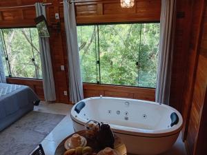 a bathroom with a tub in a room with windows at Cabana Zanetti in Santa Teresa