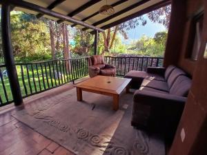 a screened in porch with a couch and a coffee table at The Witch's Cottage in Urubamba