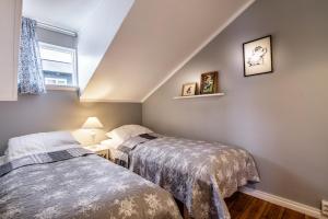 two beds in a small room with a window at Englendingavík Homestay in Borgarnes